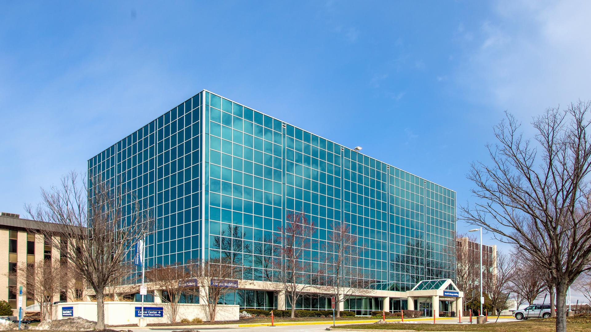 The Russell Morgan building on the campus of MedStar Health Good Samaritan Hospital is a modern blue-green glass building.
